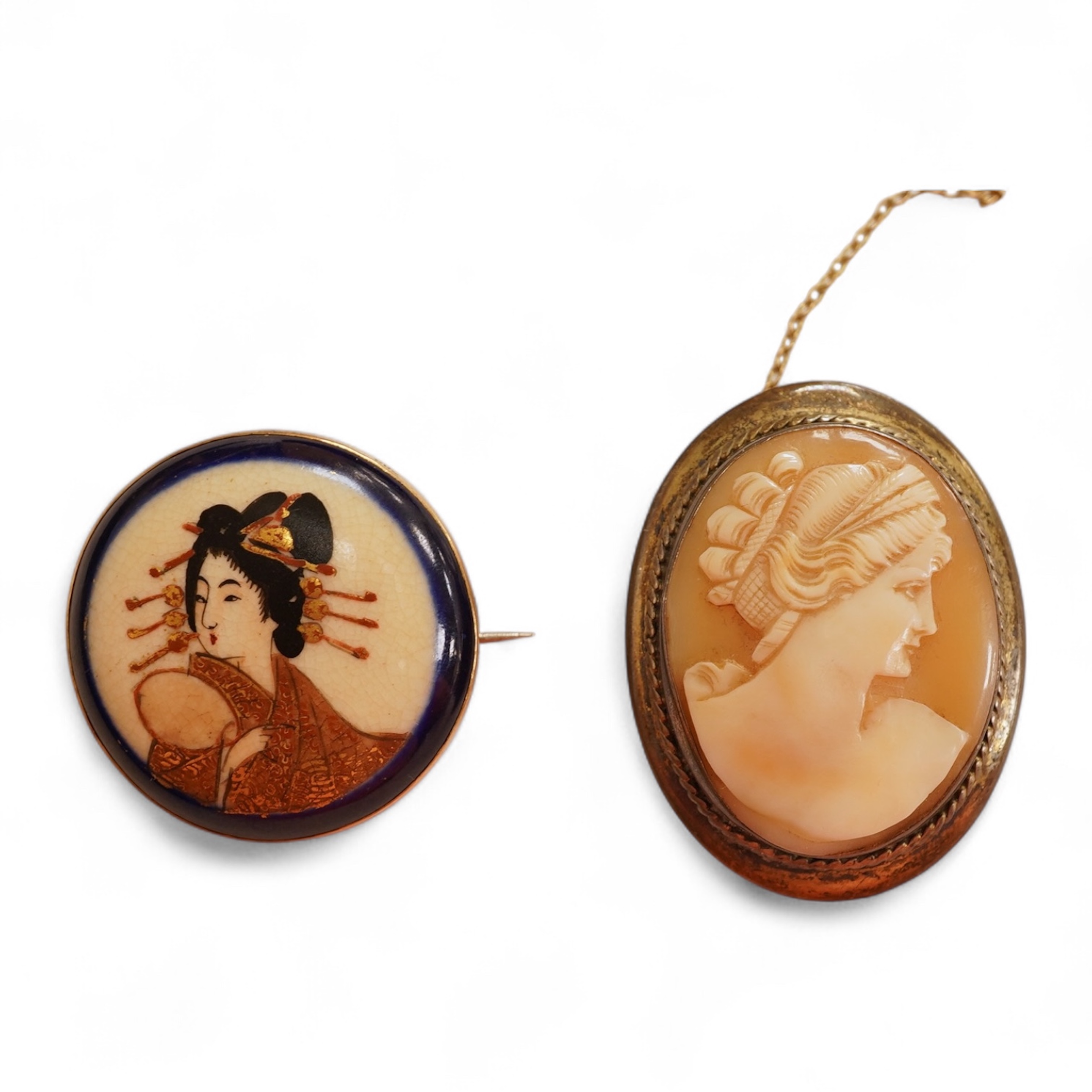 A Satsuma brooch, set with a circular Satsuma plaque depicting an oiran with gilded hair ornaments, mounted in 9ct gold, 3.3cm diameter, British hallmarks; together with an oval shell cameo brooch depicting a classical w